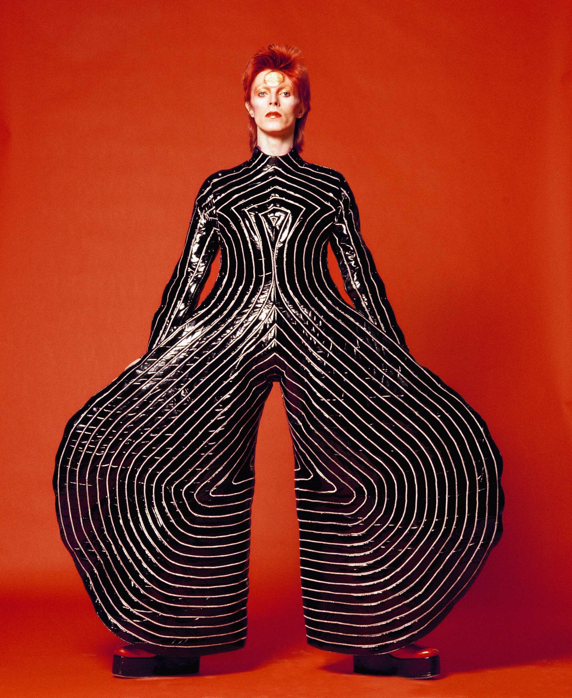 Artisten David Bowie klädd i svart, med rött hår. 