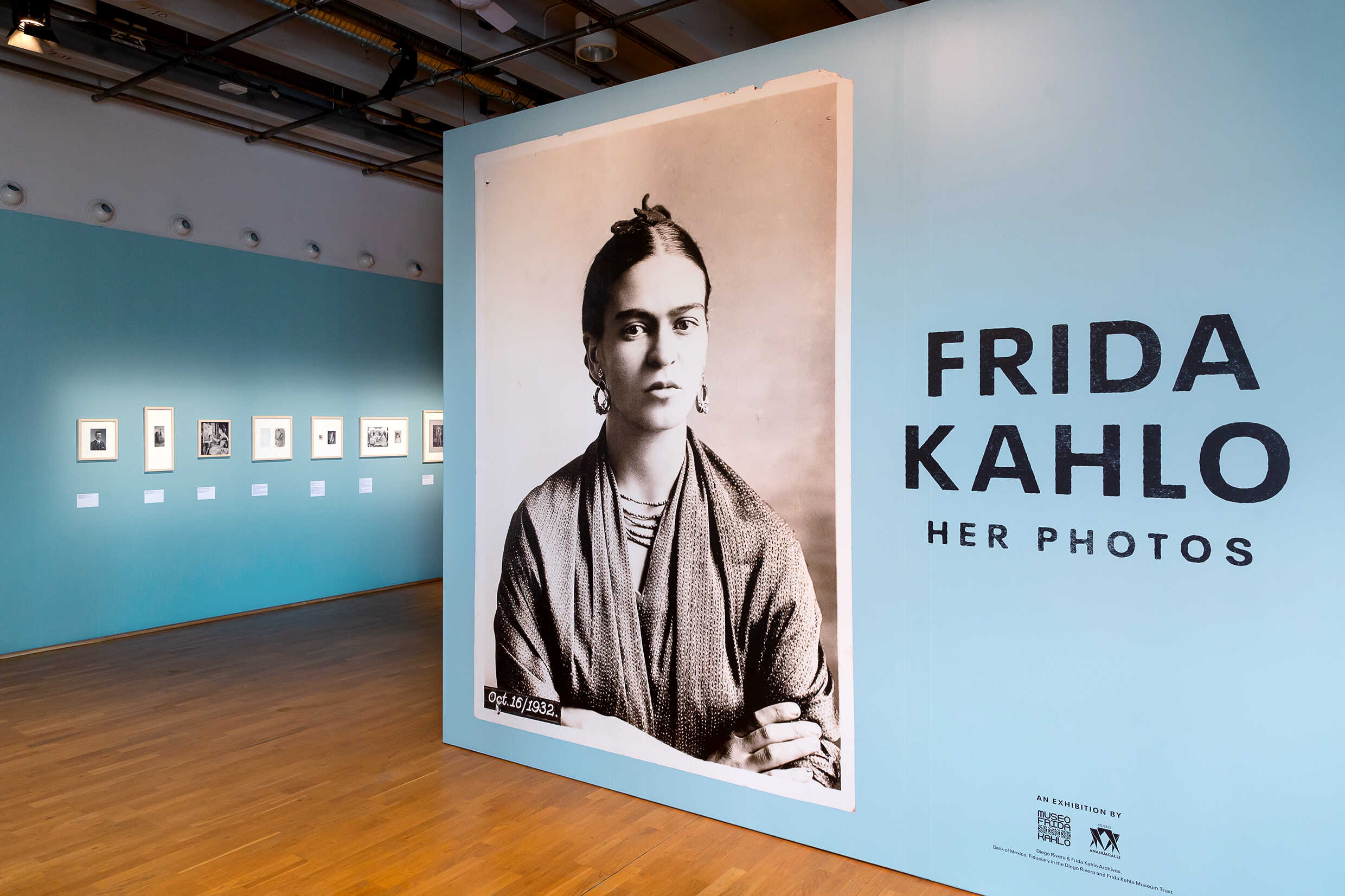 Flera fotografier av Frida Kahlo i ett galleri. 