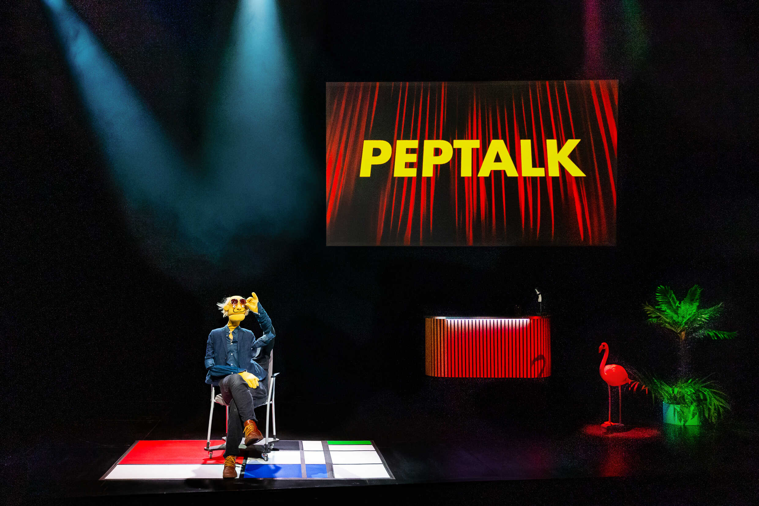 En docka på en scen med texten Peptalk bakom sig. 