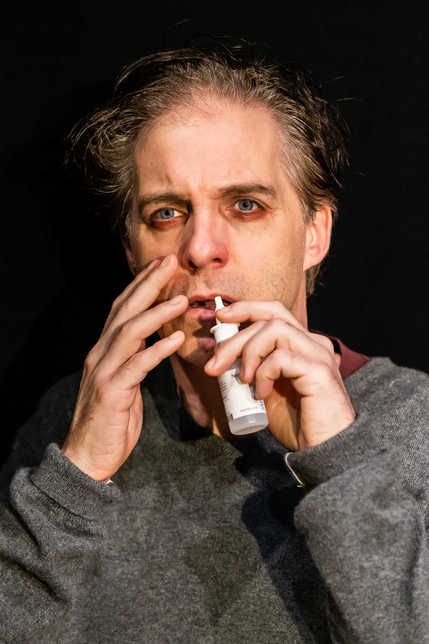 Andreas med en nässpraysflaska. Han spelas av Fredrik Meyer