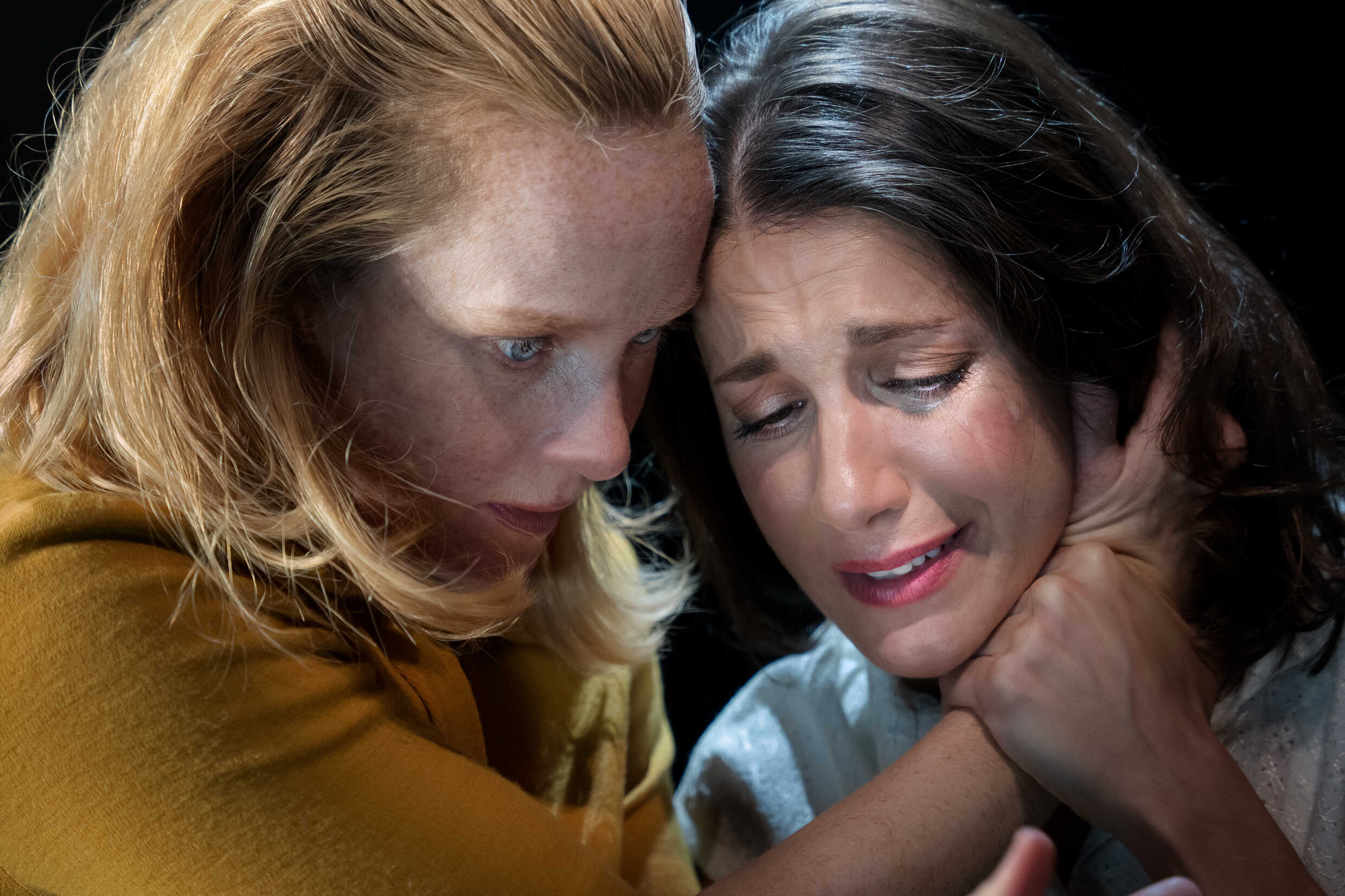 En kvinna som gråter blir tröstad av sin väninna. 