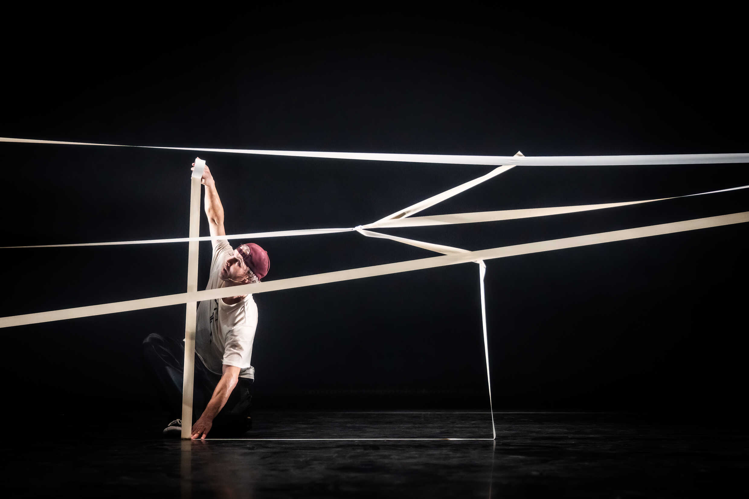 Dansaren Fredrik Benke Rydman skapar en konstruktion med hjälp av vit tejp. 